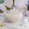 KAMMAK Teapot with Handle, Vintage Porcelain Tea Pot with Gold Trim, Blooming & Loose Leaf Teapot, Festive Holiday Serveware, Gifts for Women, Creamy White 28 oz KAMMAK 8CZSY011 ceramic teapot side angle view showing silhouette