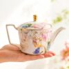 KAMMAK Teapot with Handle, Vintage Porcelain Tea Pot with Gold Trim, Blooming & Loose Leaf Teapot, Festive Holiday Serveware, Gifts for Women, Tulip 22 oz KAMMAK 8CZNX021 ceramic teapot side angle view showing silhouette