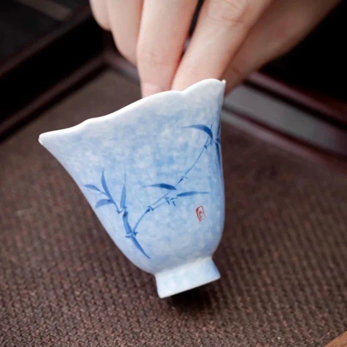 Small blue floral ceramic tea cup held in one hand KAMMAK 7KPSP669N+785N ceramic cup and saucer shape and proportion detail image 3