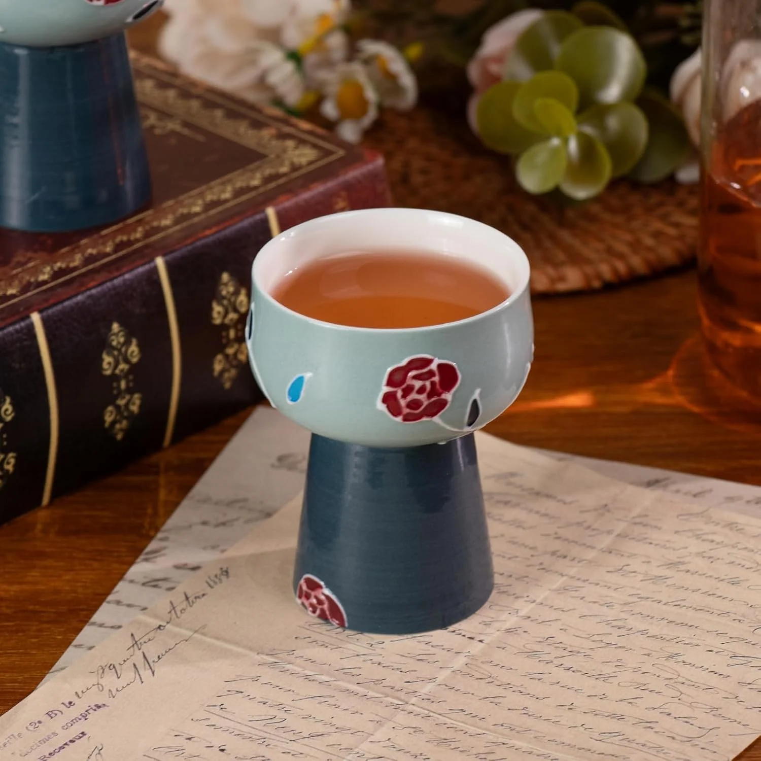 Blue floral pedestal tea cup filled with tea