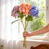 Three colorful hydrangea flower stems held by a window KAMMAK 8KPFZH004 home decor product side angle view showing silhouette