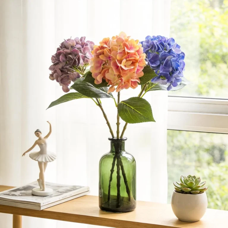 Colorful hydrangea stems arranged in a tall green glass bottle