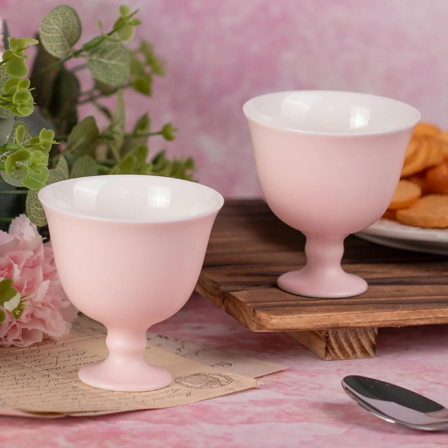 Two blush pink ceramic pedestal cups arranged together