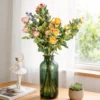 Mixed rose bouquet displayed in a green glass bottle KAMMAK 8KPFZH005 home decor product styled home decor setting image 5