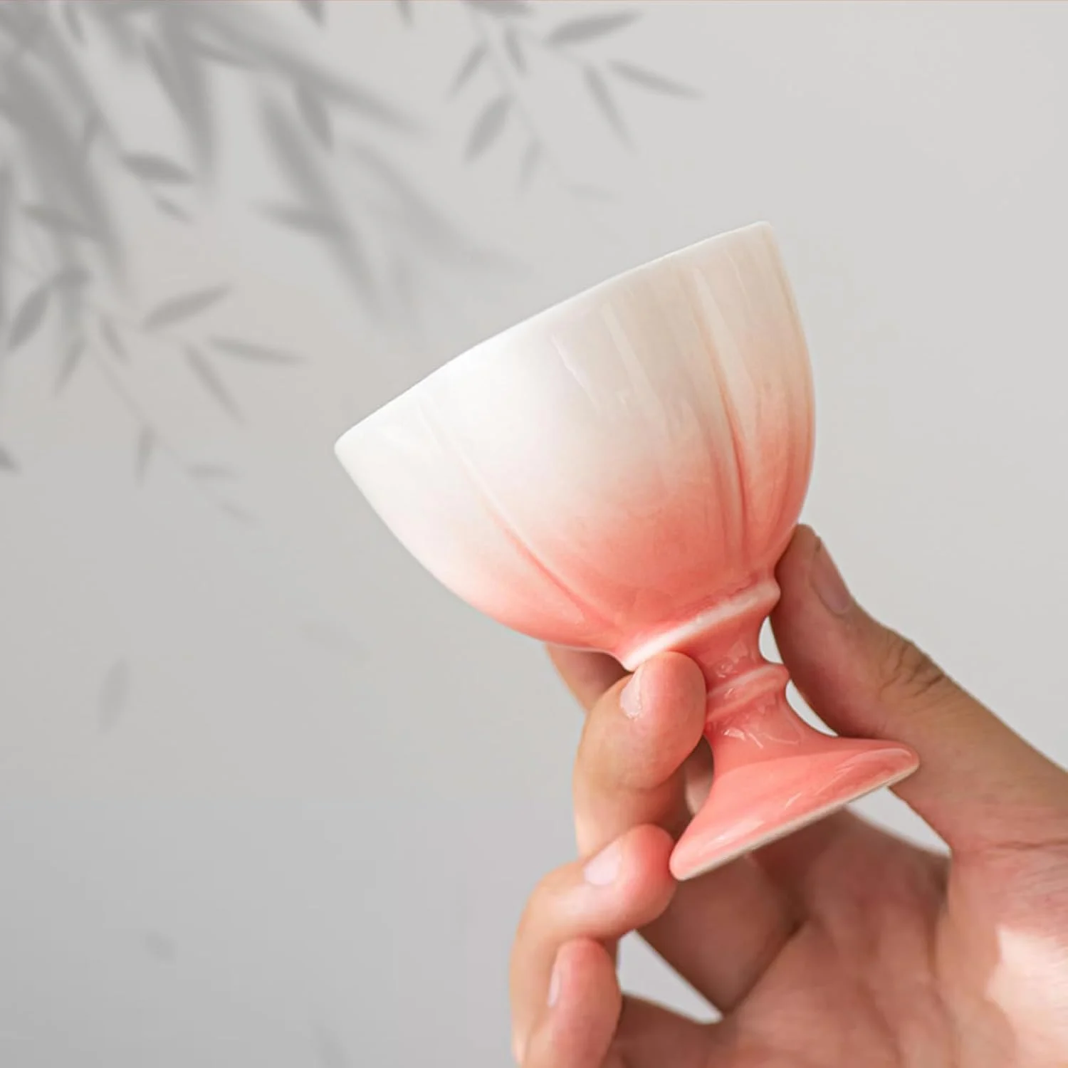Coral gradient matte tea cup held in one hand