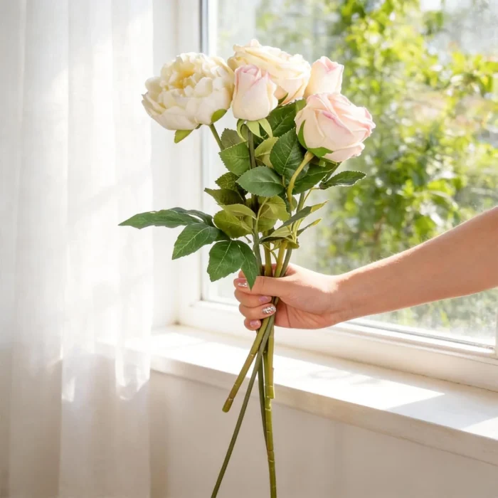 Long pale rose stems held beside a bright window KAMMAK 8KPFZH010 home decor product side angle view showing silhouette