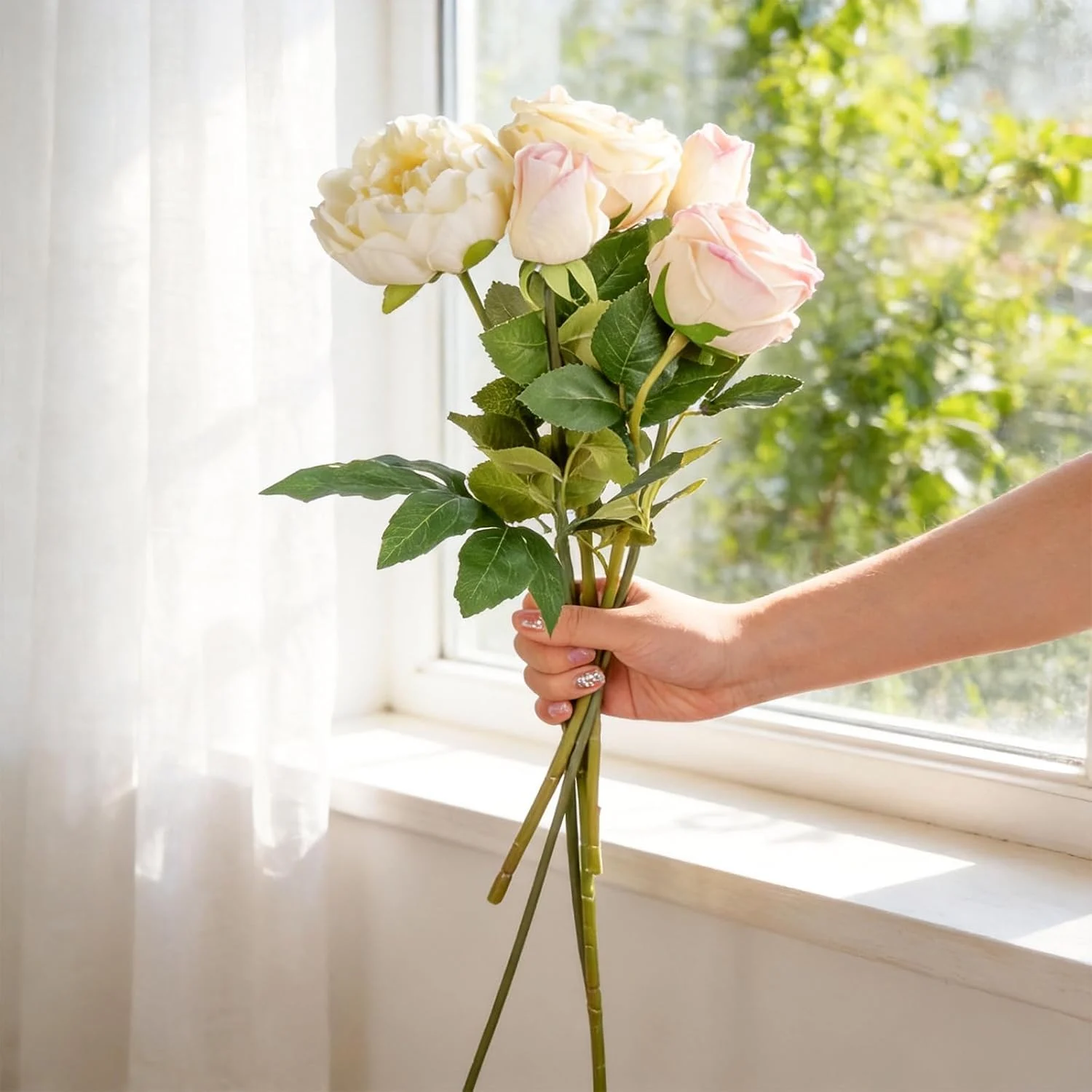 Long pale rose stems held beside a bright window