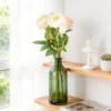Pale rose stems arranged in a green bottle on a shelf KAMMAK 8KPFZH010 home decor product styled home decor setting image 5
