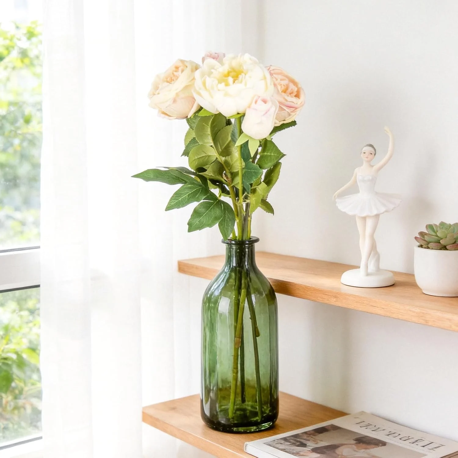 Pale rose stems arranged in a green bottle on a shelf