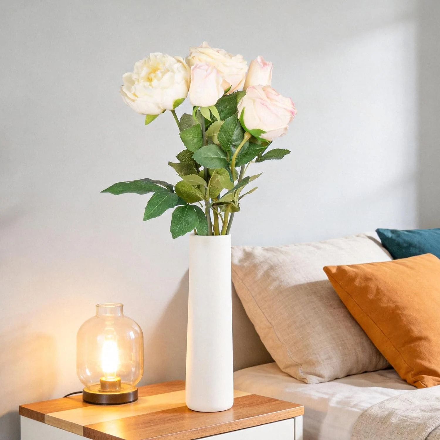 Blush and ivory roses displayed in a white bedside vase