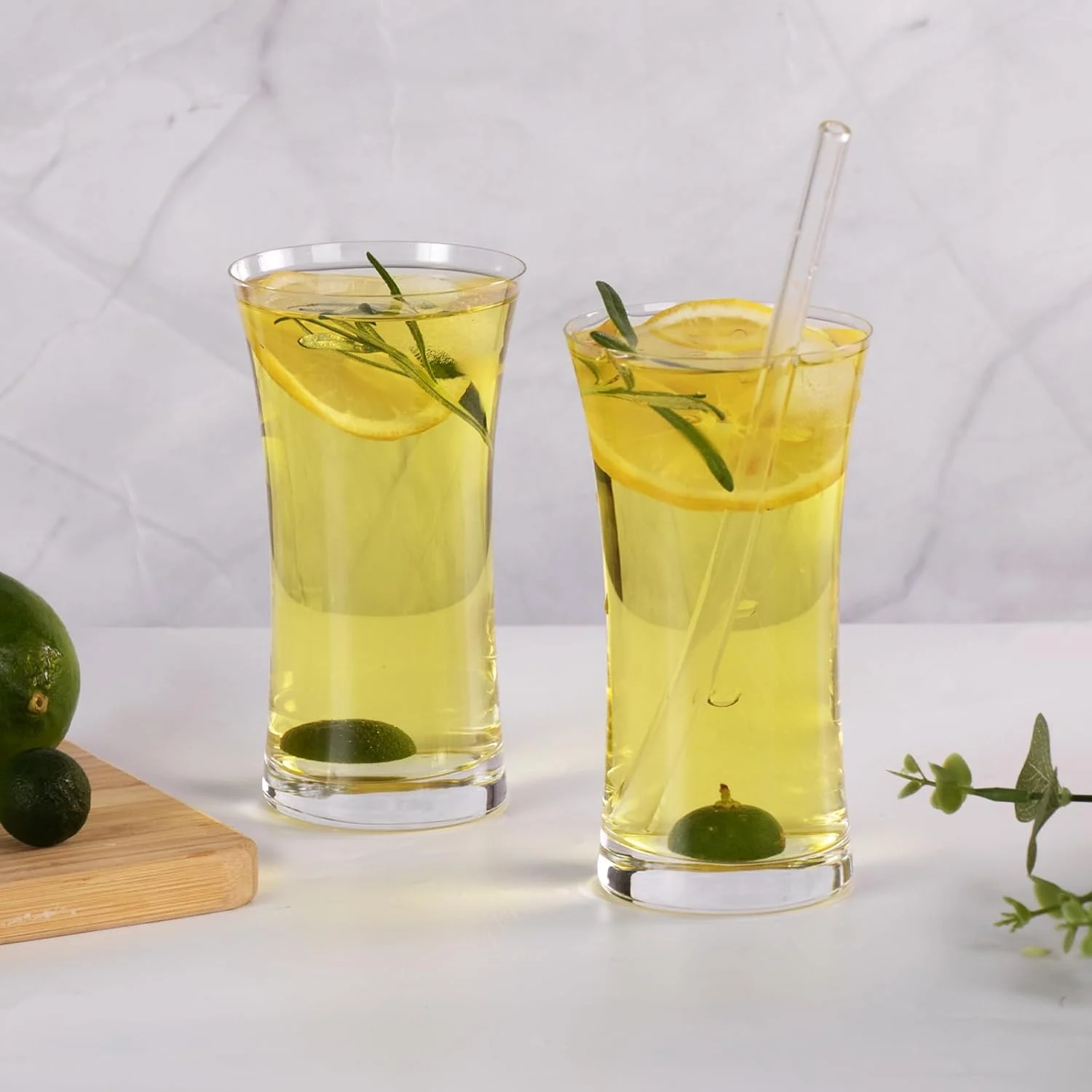 Pair of tall Collins glasses served with lime and rosemary drinks