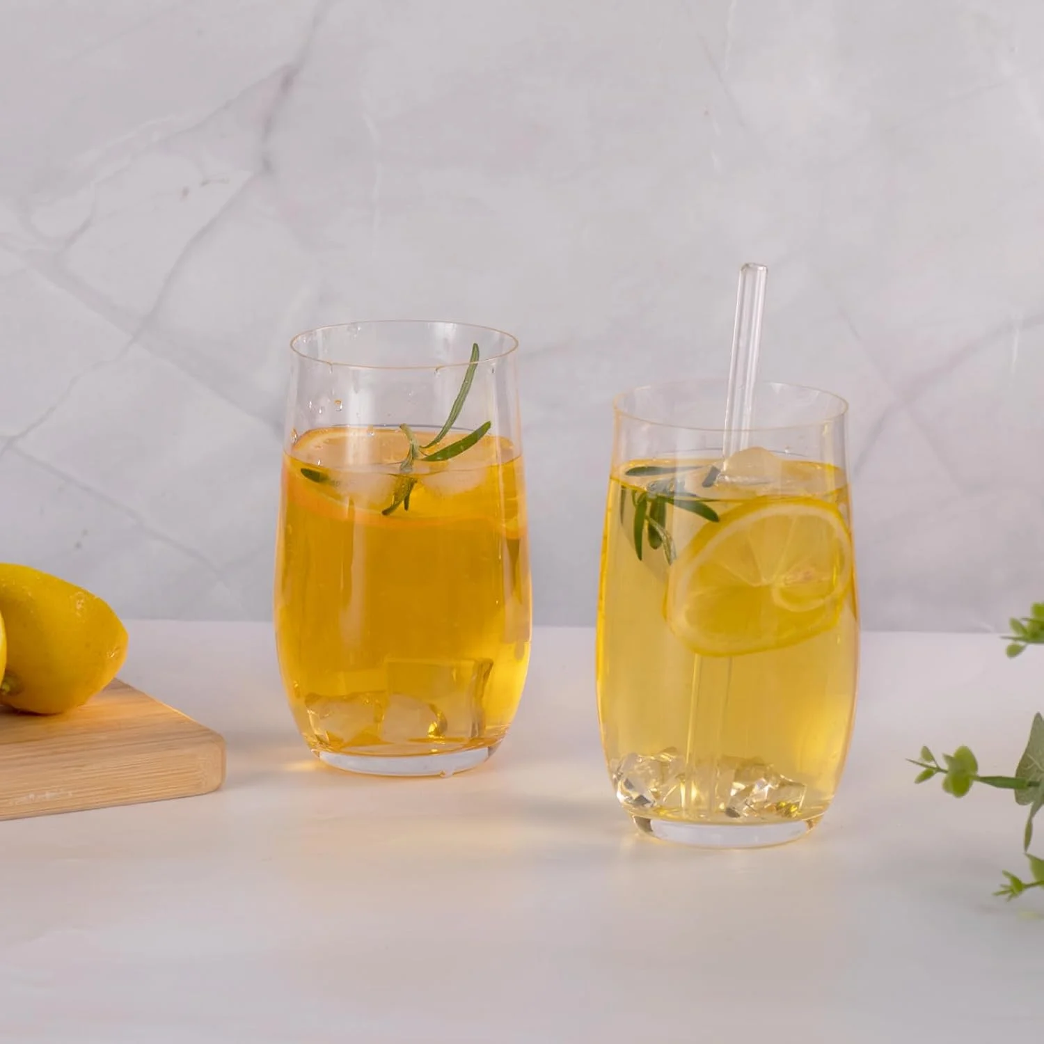 Pair of rounded highball glasses served with citrus and straws
