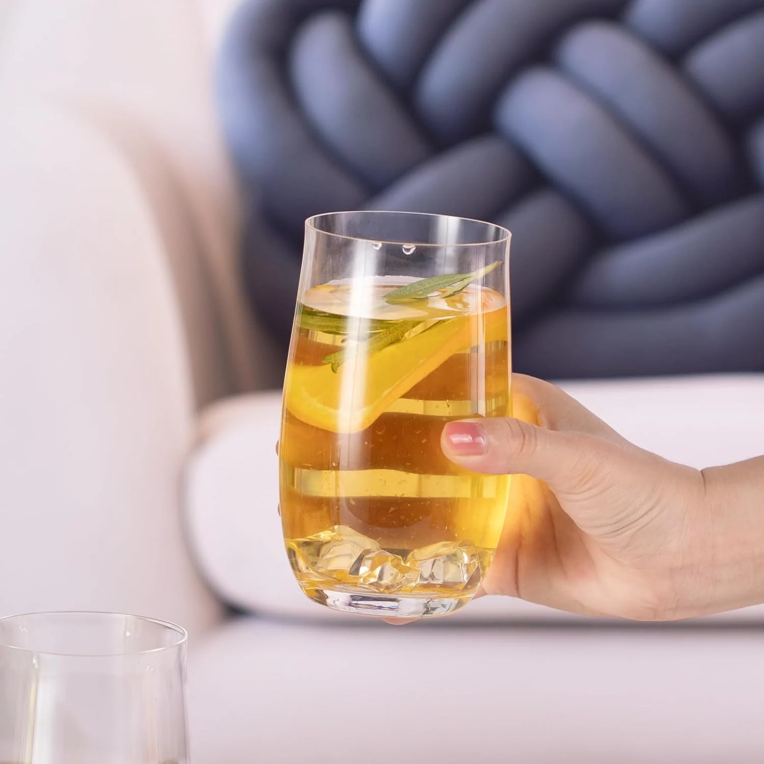 15 oz crystal highball glass held with an iced lemon drink