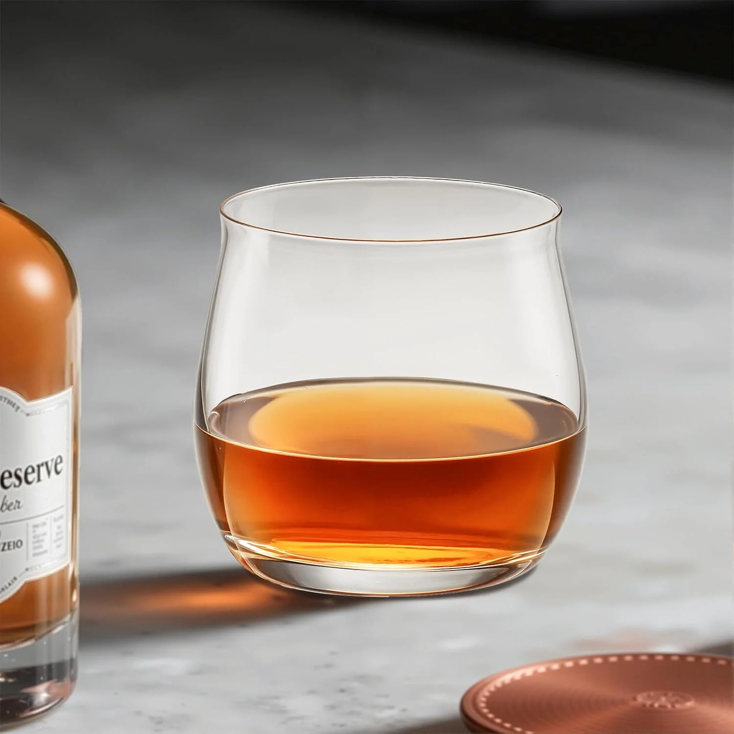 Single clear whiskey tumbler with amber liquor beside a bottle