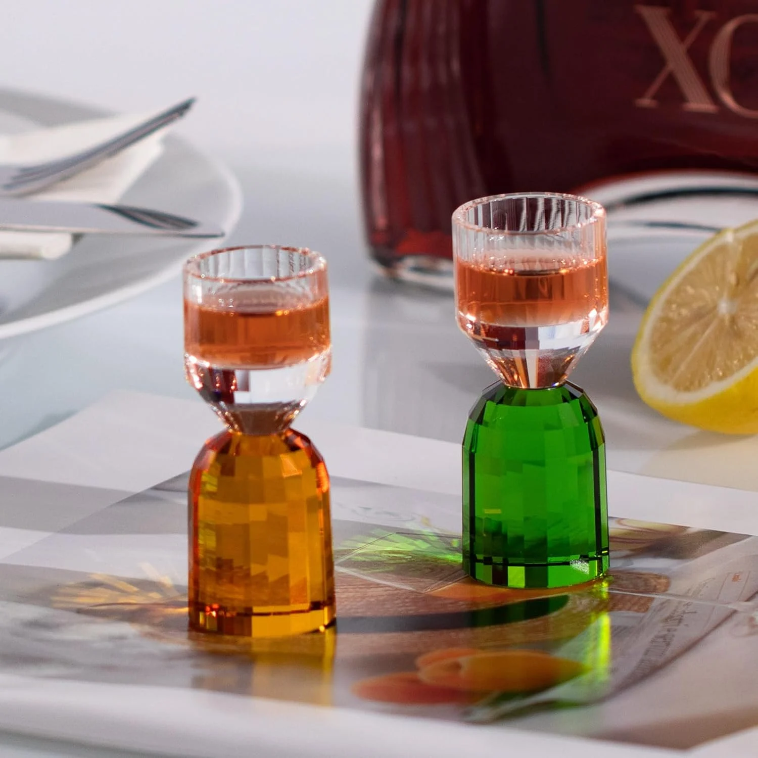 Amber and green crystal shot glasses in a tasting setting