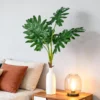 Artificial tropical-style leaves in a white vase beside a sofa KAMMAK 8KPFZH003 home decor product decorative craft detail image 7