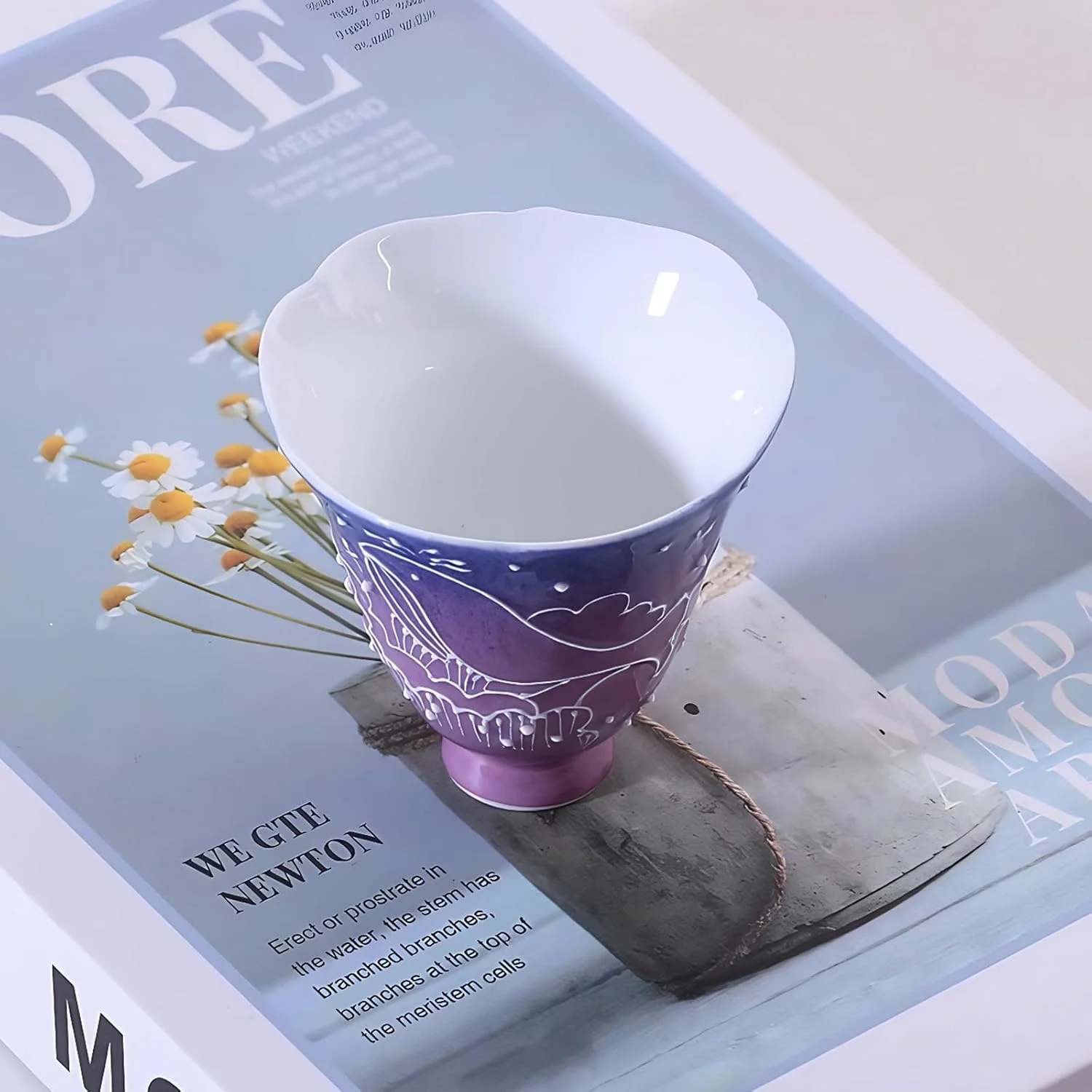 Blue-purple decorative ceramic tea cup beside flowers
