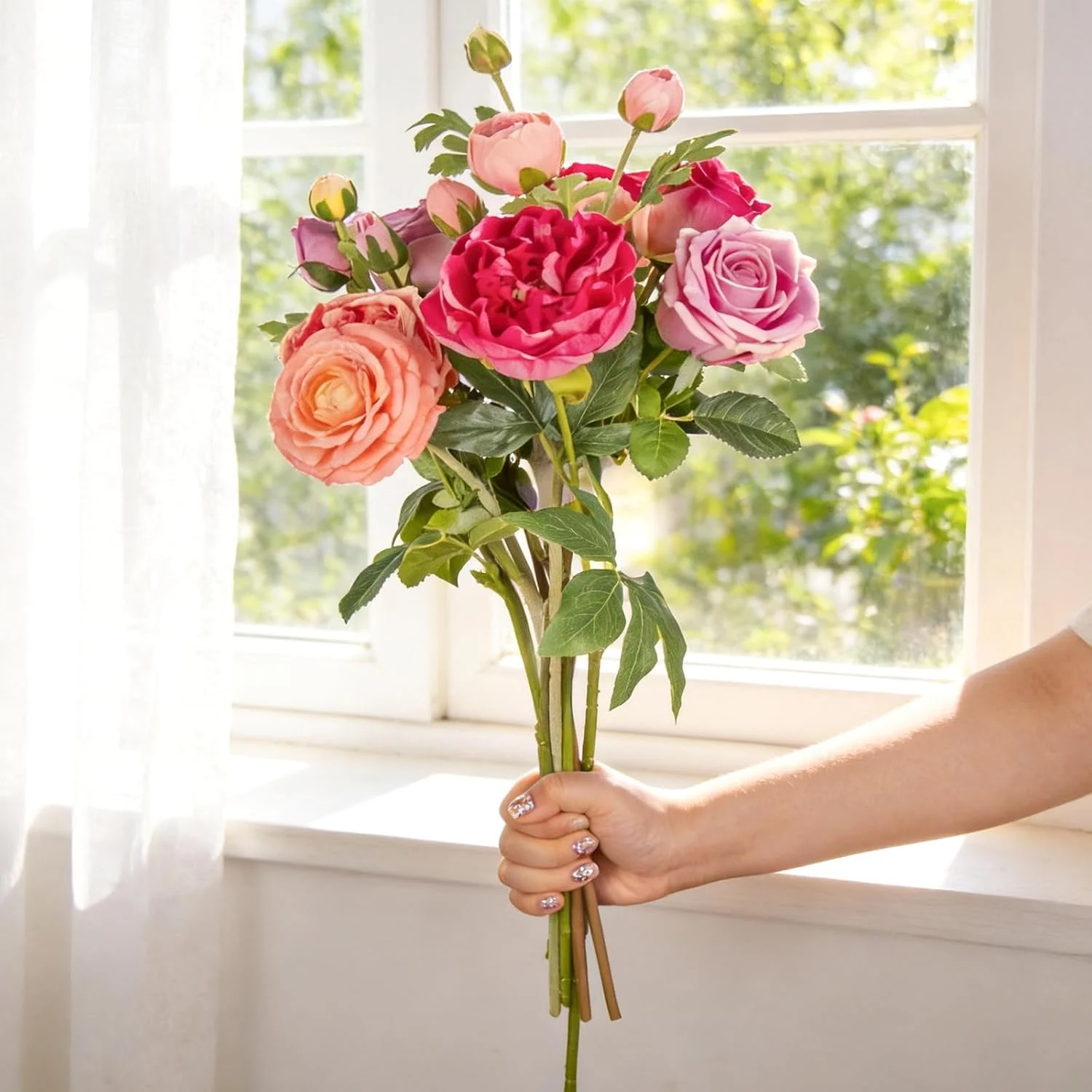 Colorful artificial rose stems held next to a window