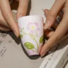 Tall pink floral ceramic tea cup held in one hand KAMMAK 7KPSP709N ceramic cup and saucer shape and proportion detail image 3