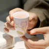Pink flower ceramic tea cup held with tea inside KAMMAK 7KPSP709N ceramic cup and saucer close-up material texture detail image 4