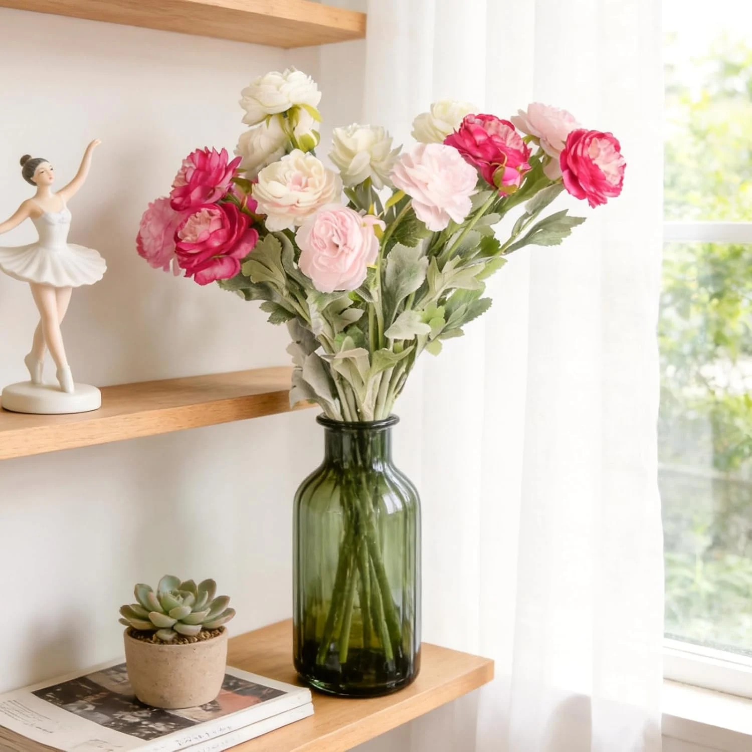 Pink and cream flowers arranged in a green glass bottle