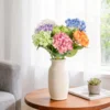 Rainbow hydrangeas arranged in a cream vase on a round table KAMMAK 8KPFZH009 home decor product scale and proportion view image 6