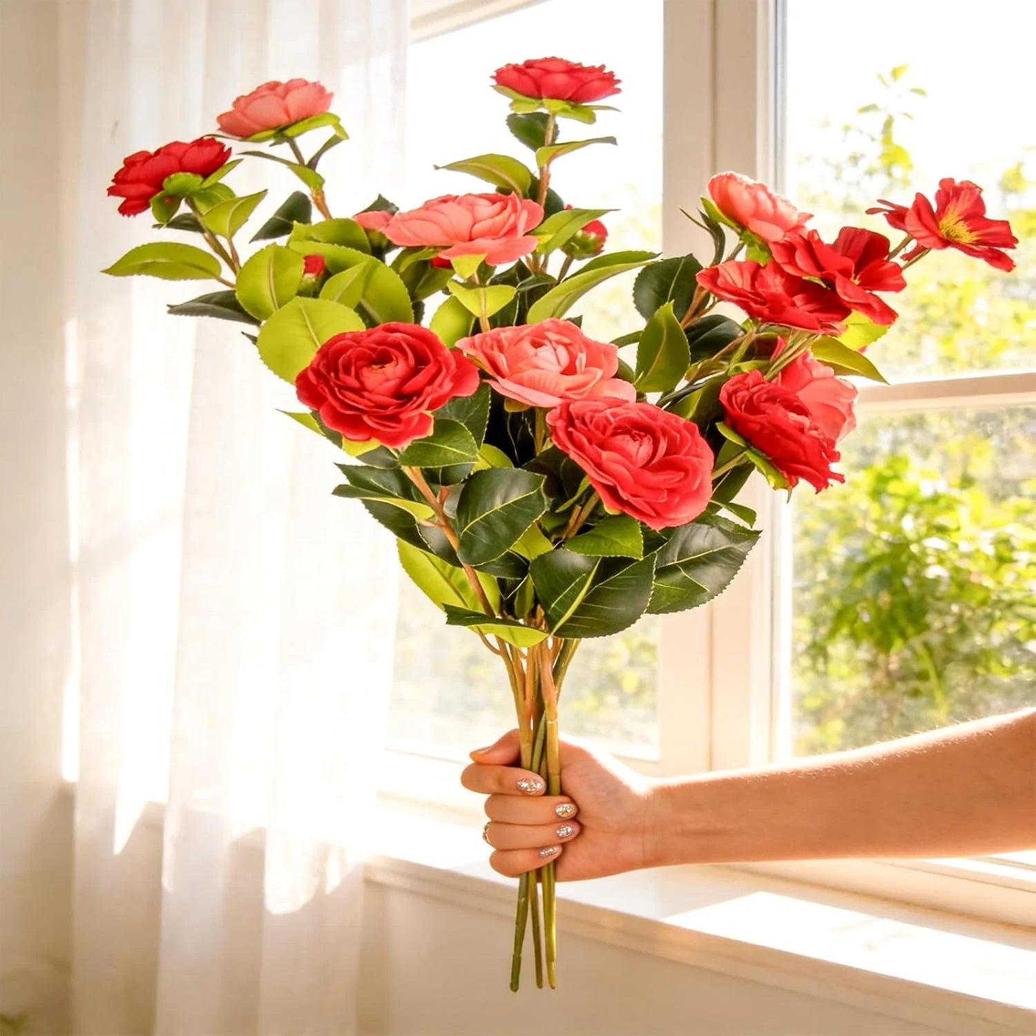 Tall red artificial flower stems held in front of a window