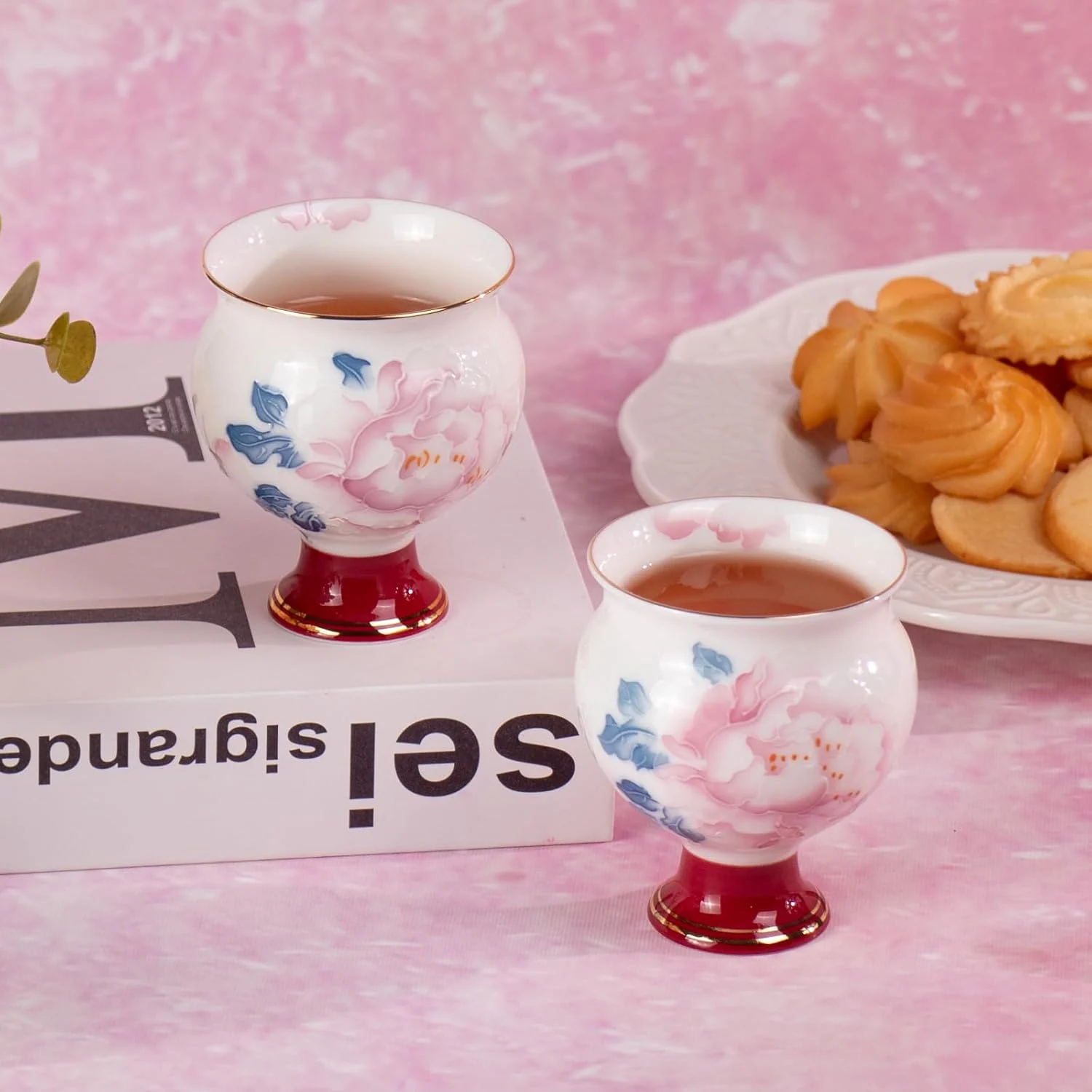 Two round peony porcelain tea cups arranged together