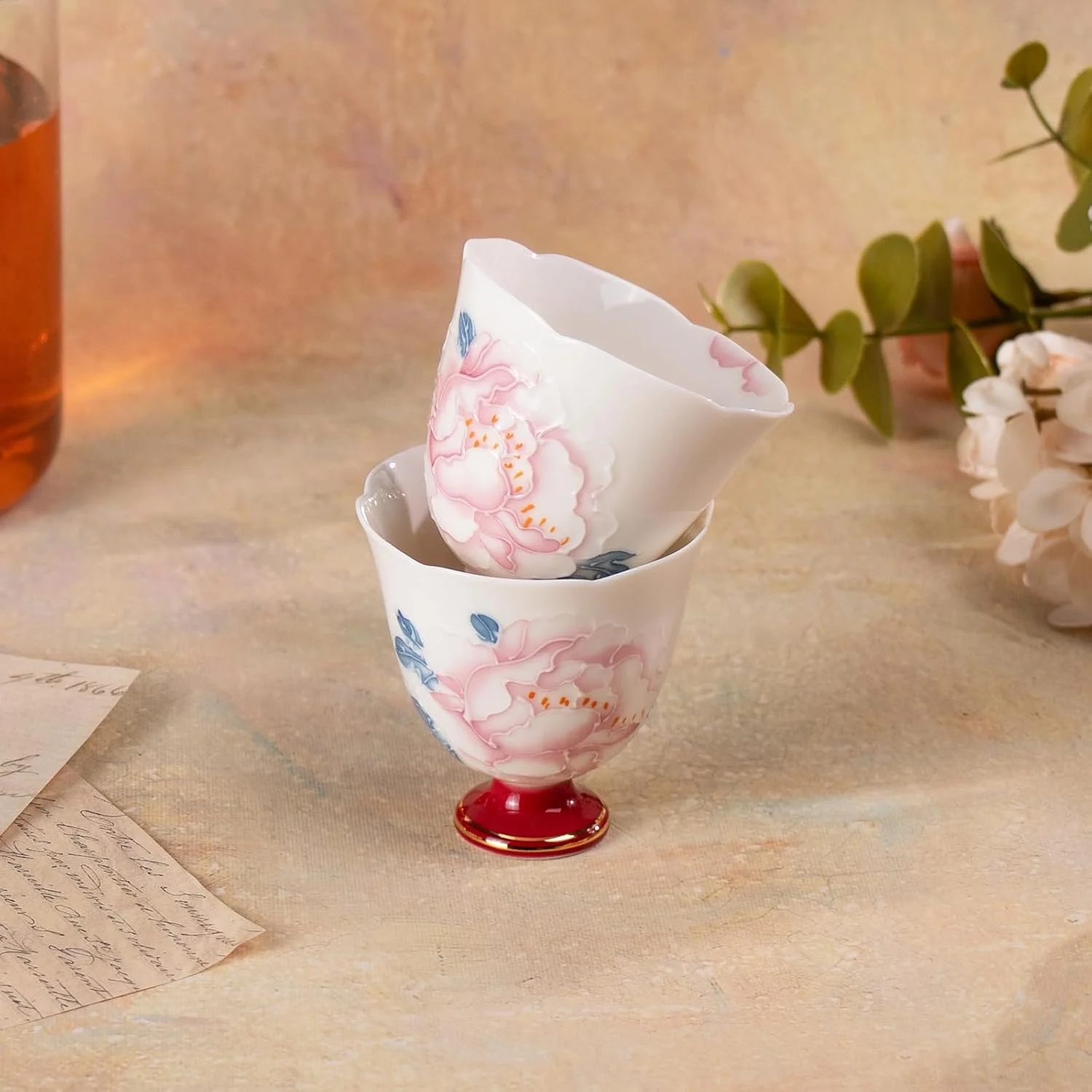 Two peony porcelain tea cups stacked together
