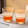 Two tapered crystal whiskey glasses in a warm table setting KAMMAK 7KPSP772N whiskey glasses scale and proportion view image 6