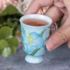 Blue lily KAMMAK ceramic tea cup held by its small foot KAMMAK 7KPSP734N+735N-US ceramic cup and saucer close-up material texture detail image 4