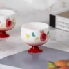 Single KAMMAK 698N pomegranate tea cup displayed beside books KAMMAK 7KPSP698N ceramic cup and saucer scale and proportion view image 6