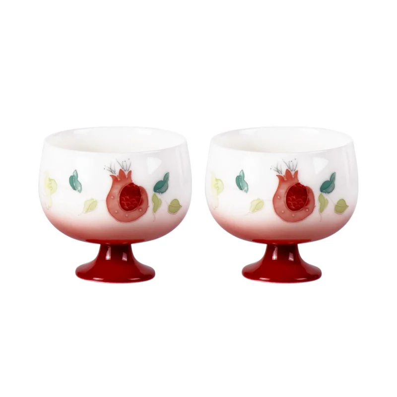 Two pomegranate-pattern porcelain tea cups with red footed bases