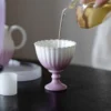 Tea being poured into a purple KAMMAK chrysanthemum footed cup KAMMAK 7KPSP702N ceramic cup and saucer scale and proportion view image 6