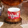 Close view of the red KAMMAK porcelain tea cup and gold-tone trim KAMMAK 7KPSP424N ceramic cup and saucer styled home decor setting image 5
